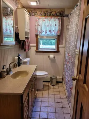 a bathroom with a sink and a toilet and a window at Lake Congamond Suffield House in Granby