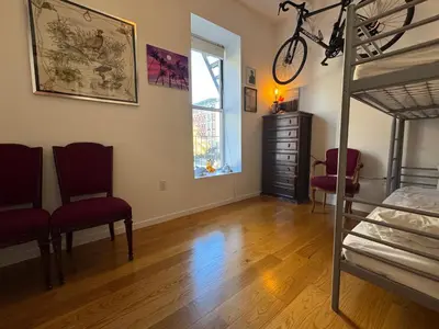 a bedroom with a bunk bed and two chairs at Large and Luxurious in Strivers Row in New York