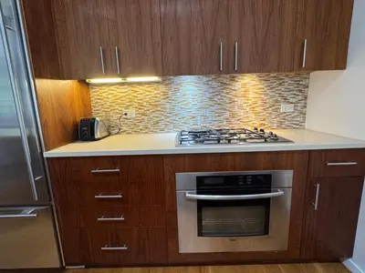 a kitchen with wooden cabinets and a stove top oven at Large and Luxurious in Strivers Row in New York