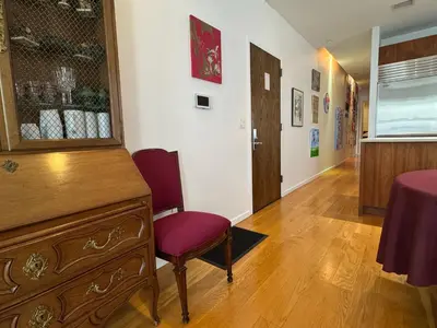 a room with a dresser and a chair and a table at Large and Luxurious in Strivers Row in New York