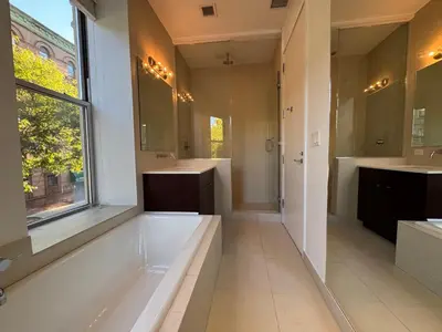 a bathroom with a tub and two sinks and a window at Large and Luxurious in Strivers Row in New York