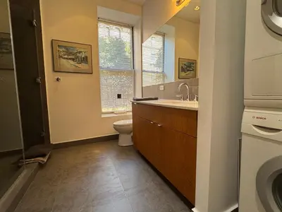 a bathroom with a toilet and a sink and a window at Large and Luxurious in Strivers Row in New York