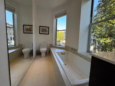 a bathroom with two toilets and a tub and two sinks at Large and Luxurious in Strivers Row in New York