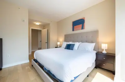 a bedroom with a large white bed and two lamps at Luxury Apt with Pool in Stamford