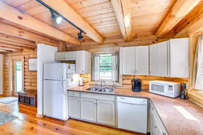 a kitchen with white appliances and a wooden ceiling at Lakefront Corinth Log Home Private Dock, Fire Pit in Lake Luzerne