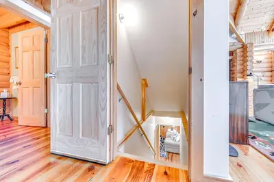 a door leading into a room with wooden floors at Lakefront Corinth Log Home Private Dock, Fire Pit in Lake Luzerne