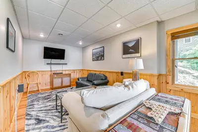 a living room with a couch and a tv at Lakefront Corinth Log Home Private Dock, Fire Pit in Lake Luzerne