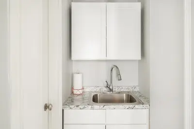 a kitchen with a sink and a white cabinet at 73-406 New 1BR 1Bth UWS Doorman Gym in New York