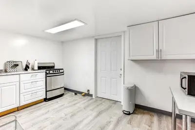 an empty kitchen with white cabinets and a stove at Convenient Apt 2 Mi to Sprain Ridge Park! in Yonkers