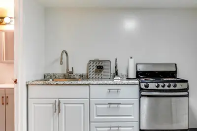 a white kitchen with a stove and a sink at Convenient Apt 2 Mi to Sprain Ridge Park! in Yonkers