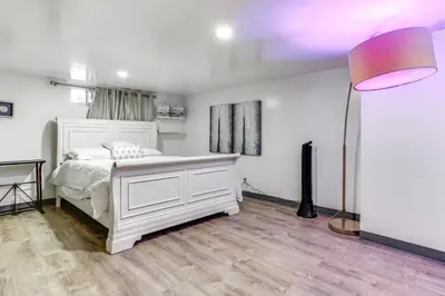 a bedroom with a white bed and a lamp at Convenient Apt 2 Mi to Sprain Ridge Park! in Yonkers