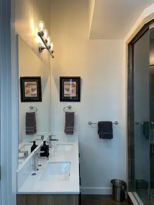 a white bathroom with two sinks and a shower at Urban Peak Escape in Lenox