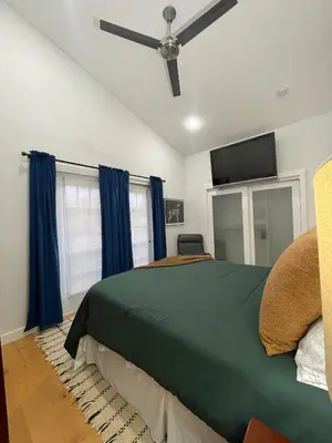 a bedroom with a green bed and a ceiling fan at Urban Peak Escape in Lenox