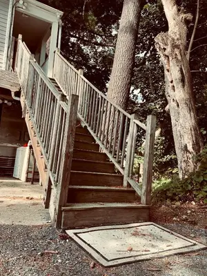 a wooden staircase leading to a house with a tree at Urban Peak Escape in Lenox