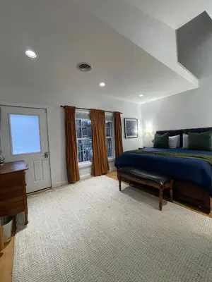 a large bedroom with a blue bed and a window at Urban Peak Escape in Lenox