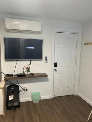 a room with a flat screen tv on a wall at Cozy apt 30mins from Times square!!! in Corona