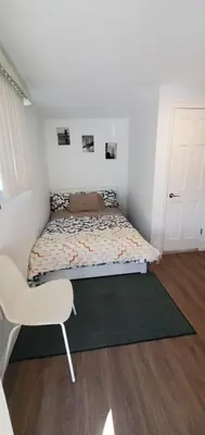 a small bedroom with a bed and a chair at Cozy apt 30mins from Times square!!! in Corona