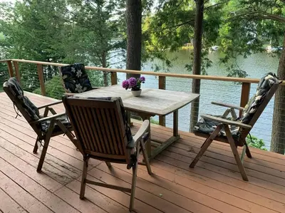 a wooden table and chairs on a deck with a view of the water at Lake Haven in Monterey