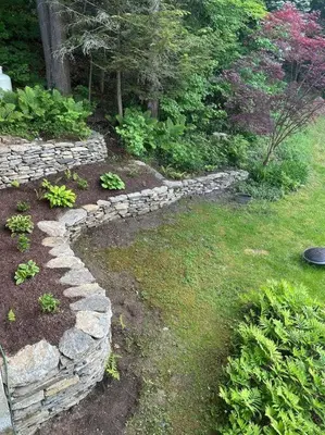 a garden with a stone wall in the grass at Lake Haven in Monterey