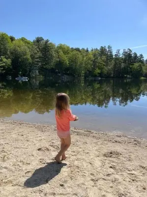 a little girl standing on the beach near a lake at Lake Haven in Monterey