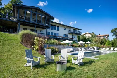 a group of chairs sitting in the grass in front of a house at Hudson House in Newburgh