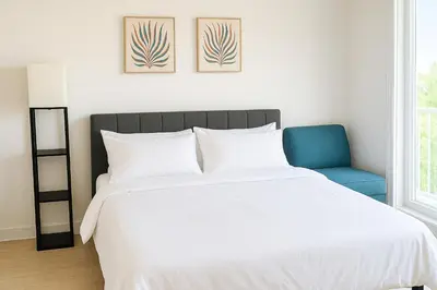 a bedroom with a white bed and a blue chair at Luxury Stay for NYC visit Jersey City 7 Min Walk NYC Train Station in Jersey City