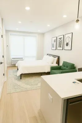 a living room with two beds and a couch at Luxury Stay for NYC visit Jersey City 7 Min Walk NYC Train Station in Jersey City