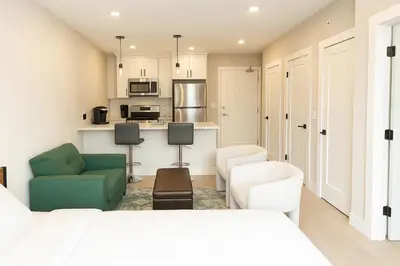 a living room with a bed and a kitchen at Luxury Stay for NYC visit Jersey City 7 Min Walk NYC Train Station in Jersey City