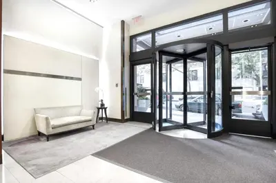 a living room with a chair and a glass door at UWS 1BR w Elevator Gym nr Central Park NYC-686 in New York