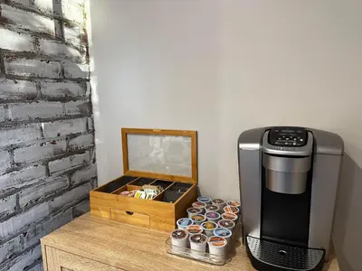 a coffee dispenser and a box of cupcakes next to a coffee machine at Norwalk Retreat in Norwalk