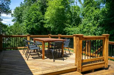 a wooden deck with a table and chairs on it at Norwalk Retreat in Norwalk