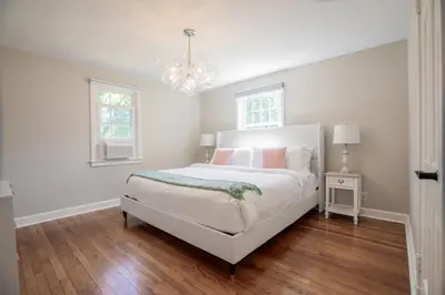 a white bedroom with a bed and a chandelier at Norwalk Retreat in Norwalk