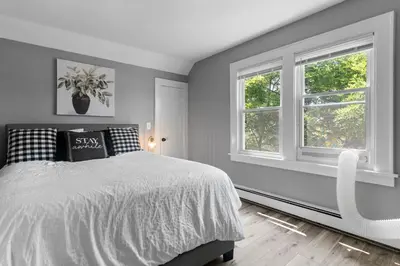 a bedroom with a bed and two windows at Centrally Located Stamford Gem in Stamford