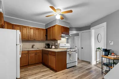 a kitchen with wooden cabinets and a ceiling fan at Centrally Located Stamford Gem in Stamford
