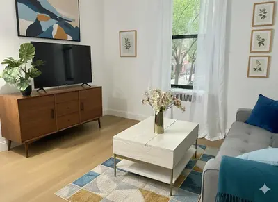 a living room with a tv and a couch and a table at Chill In The Village in New York