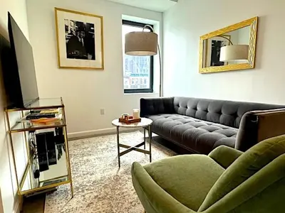 a living room with a couch and a table at Huge Modern 2 bedroom in Little Italy in New York