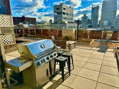 a grill sitting on top of a roof at Luxury in Little Italy 2 Bedroom Private Balcony in New York