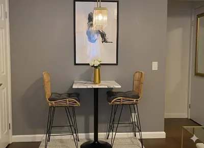 a table with two chairs and a vase with flowers at West Village Lush Green in New York