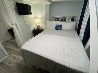 a bedroom with a large bed with white sheets at Oasis in New Jersey - 2BR NYC Access in West New York
