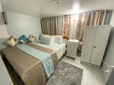 a small bedroom with two beds and a window at Oasis in New Jersey - 2BR NYC Access in West New York
