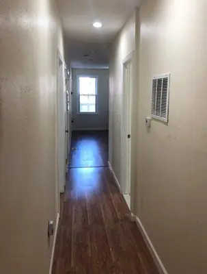 a hallway of an empty room with wood floors and a window at Spacious and private apartment with 3 bedrooms and 1 bathroom near Newark International Airport EWR and New York City, MetLife Stadium FIFA World Cup 20 minutes away in Newark