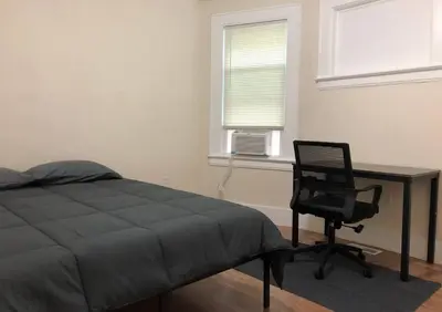 a bedroom with a bed and a desk and a chair at Spacious and private apartment with 3 bedrooms and 1 bathroom near Newark International Airport EWR and New York City, MetLife Stadium FIFA World Cup 20 minutes away in Newark