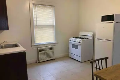 a kitchen with a white stove and a refrigerator at Spacious and bright 2-bedroom apartment with 1-bathroom and private street entrance, MetLife Stadium FIFA World Cup 25 minutes away in Paterson