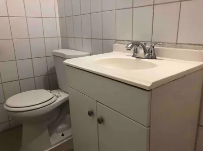 a bathroom with a white sink and a toilet at Spacious and bright 2-bedroom apartment with 1-bathroom and private street entrance, MetLife Stadium FIFA World Cup 25 minutes away in Paterson