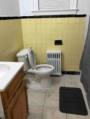 a bathroom with a white toilet and a sink at Spacious 2-bedroom apartment with 1-bathroom and private street entrance, MetLife Stadium FIFA World Cup 25 minutes away in Paterson