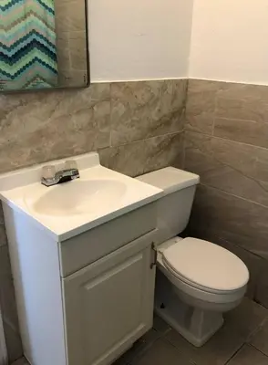 a bathroom with a white sink and a toilet at Spacious 2-bedroom apartment with 1-bathroom and private street entrance, MetLife Stadium FIFA World Cup 25 minutes away in Paterson