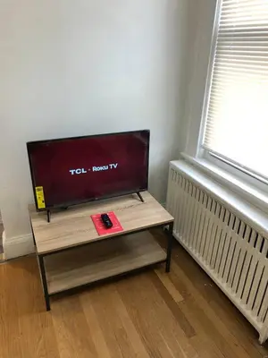 a tv sitting on a table next to a window at Spacious 2-bedroom apartment with 1-bathroom and private street entrance, MetLife Stadium FIFA World Cup 25 minutes away in Paterson
