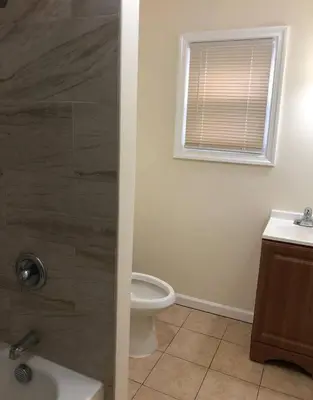 a bathroom with a shower and a toilet and a window at Large and private 3 bedroom and 1 bathroom apartment near Newark International Airport EWR and New York City, MetLife Stadium FIFA World Cup 20 minutes away in Newark