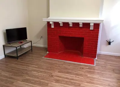 a red brick fireplace with a tv in a room at Large and private 3 bedroom and 1 bathroom apartment near Newark International Airport EWR and New York City, MetLife Stadium FIFA World Cup 20 minutes away in Newark