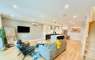 a living room with a couch and chairs and a kitchen at Huge 2000 sqft Luxury & Stylish Condo minutes to New York in Jersey City